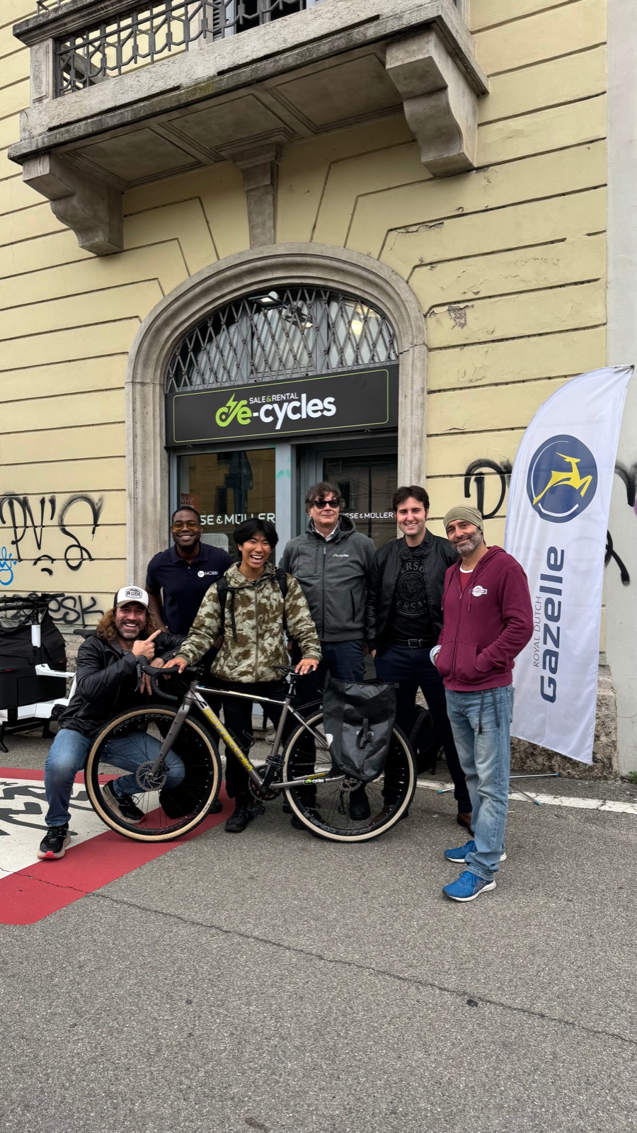 スイスの自転車店の前で、新しい自転車を提供してくれた支援者たちと記念撮影する櫛原さん